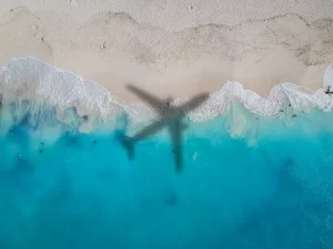 The shadow of a commercial jet on the ocean and beach of Turks and Caicos.
